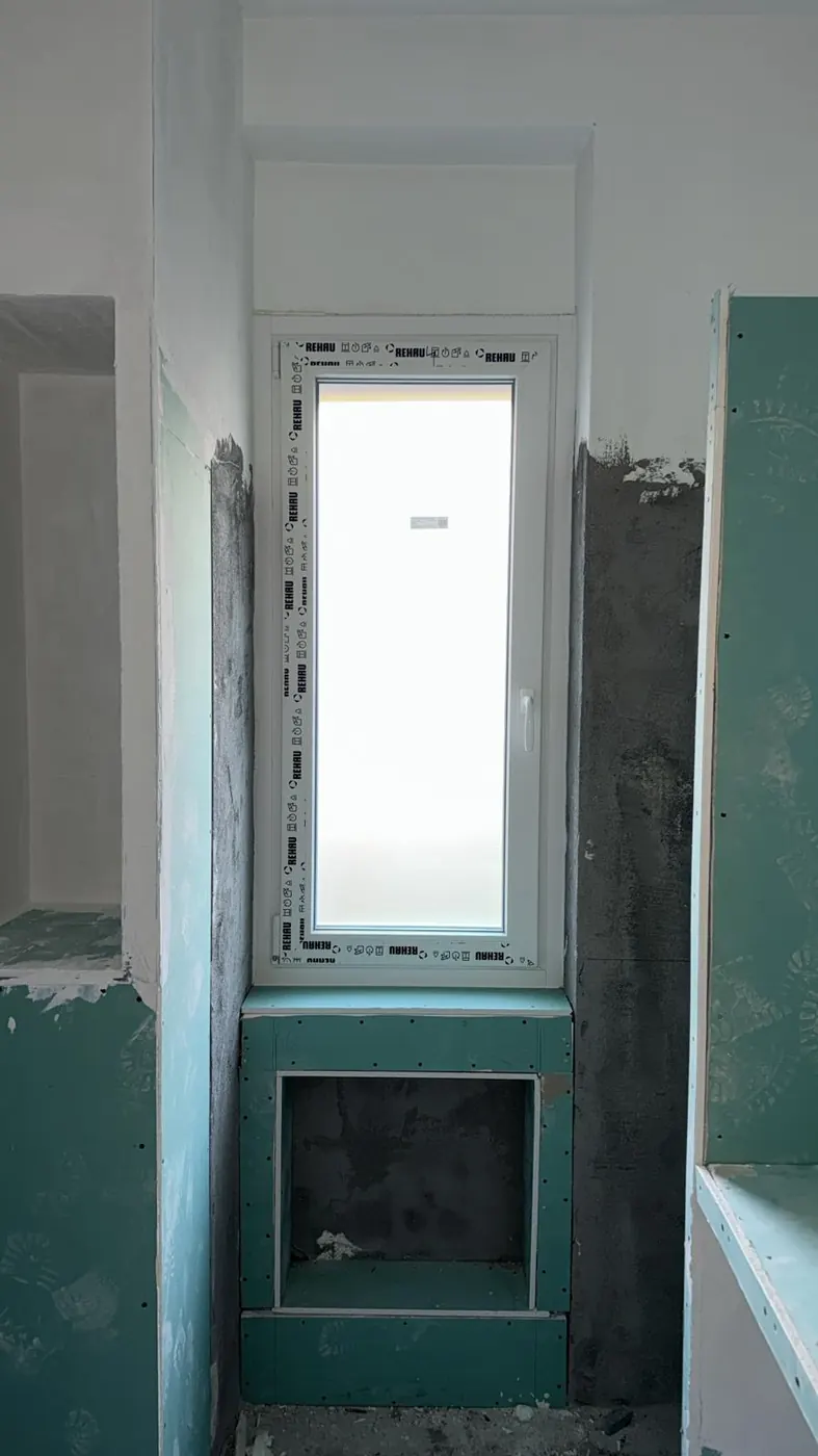 Finestra appena posata in un bagno in ristrutturazione, con il profilo ancora protetto dalla pellicola